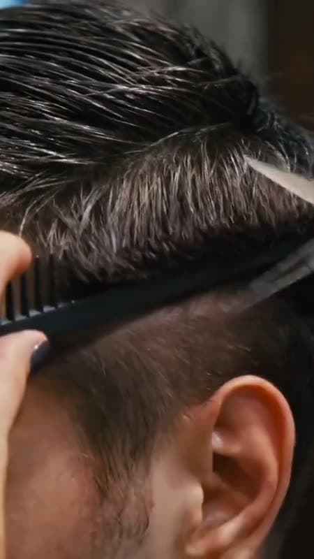 A barber laying a hot towel over a client's face