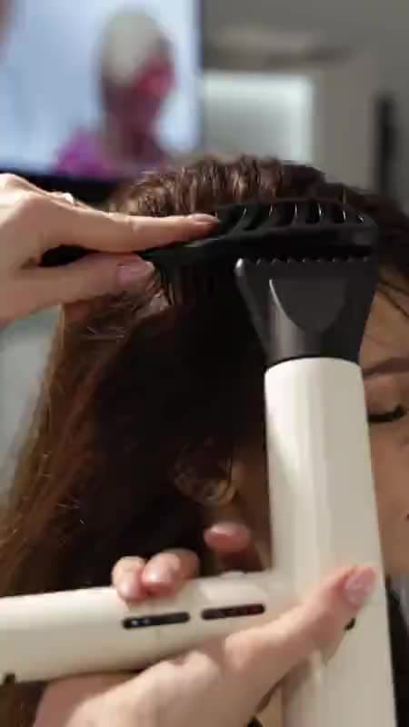 A hairdresser applying colour with a brush