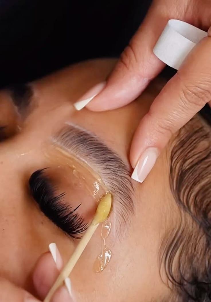 A beauty therapist applying a face mask