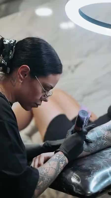 A tattoo artist at work with the machine