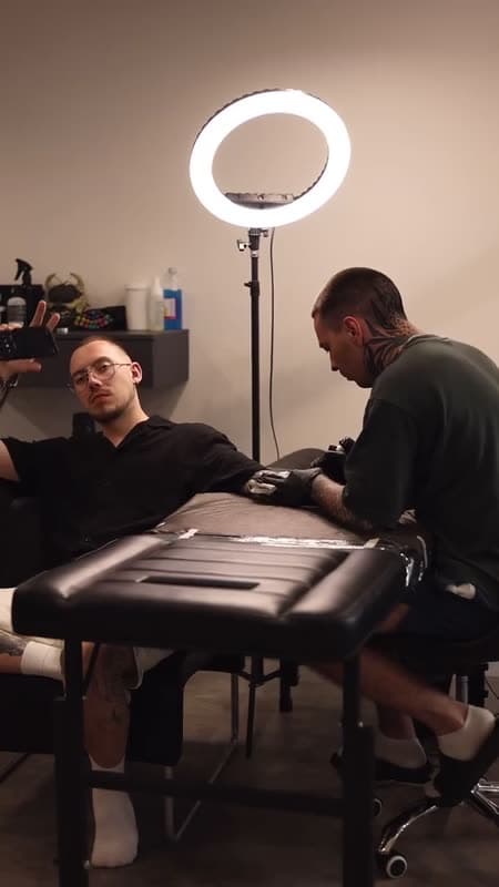 A client sitting in the chair of a tattoo studio