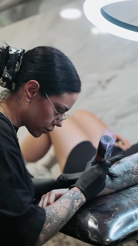 A tattoo artist going over a design with a client