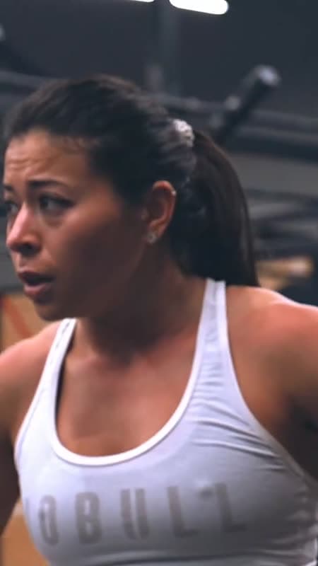 Een vrouw in een sporttop, geconcentreerd tijdens een training