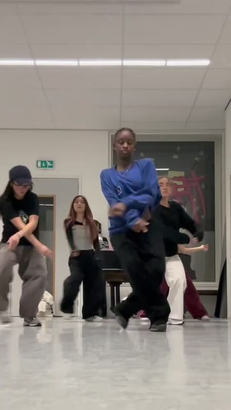 Een dansdocent doet een pas voor aan een groep in de les