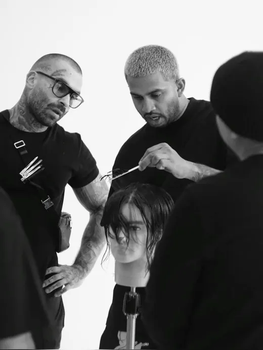 A hairdresser demonstrating a cut on a training head